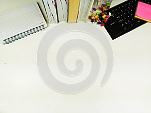 Flat lay, white desk in the office with layout space.with office equipment such as pencils, notebooks and keyboards at the top.