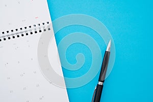 Flat lay of white empty clean calendar with pen on blue background with copy space. Business important remind schedule, holiday