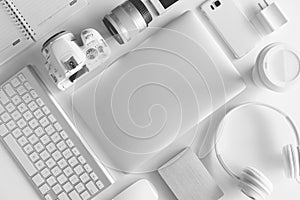 Flat lay of white office desk table with many white gadgets
