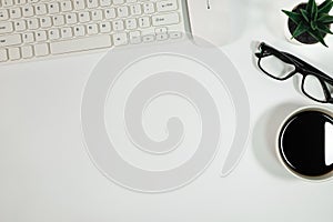 Flat lay, White office desk table. View from above with keyboard, computer mouse, plant potted, succulents, eyeglasses and cup of