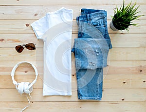 Flat lay White tshirt mockup short jeans headphones and Sunglasses on brown wooden background. Template