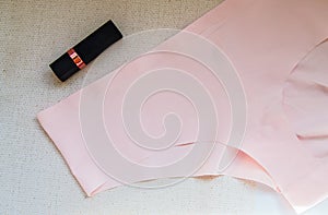 Flat lay women`s accessories - underwear and cosmetics.The view from the top women`s pink bikini panties and lipstick. The conce