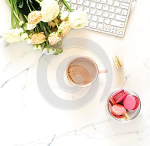 Flat lay women`s office desk. Female workspace with laptop,  flowers pink ranunkulus