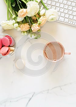 Flat lay women`s office desk. Female workspace with laptop,  flowers pink ranunkulus