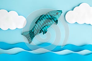 Flat lay of wooden fish with water and clouds made of paper abstract