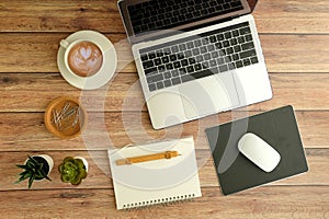 Flat lay workspace. Woman hand with coffee cup, smartphone, computer, notebook, planner and stationary with copy space on marble