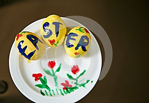Flat lay of yellow Easter eggs on a painted white saucer