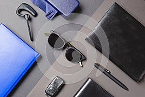 Flat layer of men accessories, sunglasses, agenda, car key, pen over creative background