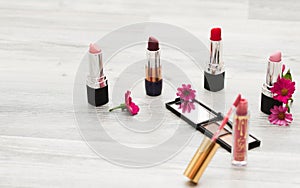 Flat lying, image of cosmetics. Top view of women`s makeup table including lipsticks, eye patches, foundation, brushes and others