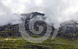 Flat mountain peak shrouded in low clouds photo