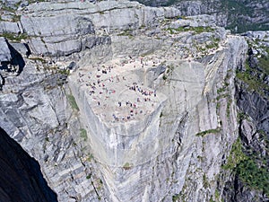 Flat rock Preikestolen over fjord Lysefjorden is natural attraction. Top view and flight down above cliff. Preacher`s Pulpit or P