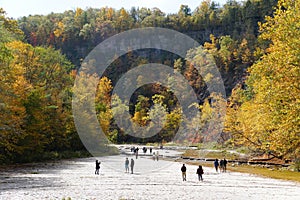 The flat rock and river bed at Taughannock Falls with the background of fall foliage in Upstate New York