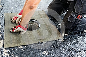 Flat roof installation. Heating and melting bitumen roofing felt