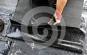 Flat roof installation. Heating and melting bitumen roofing felt