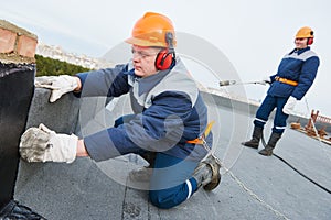 Flat roof installation. Heating and melting bitumen roofing felt