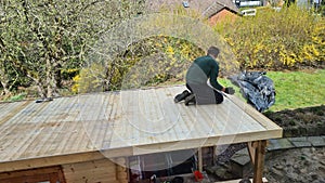 Flat roof repair: roofer welds roof waterproofing. Roof renovation with gas burner