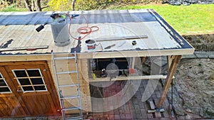 Flat roof repair: roofer welds roof waterproofing. Roof renovation with gas burner