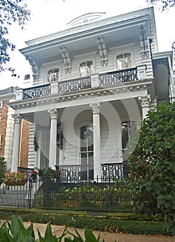 Flat roofed italianate home with columned porch photo