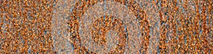 Flat sheet of iron with pattern and texture in orange rust from extensive oxidation, as an abstract background