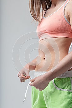 Flat belly in focus woman ties shorts, fit midriff photo