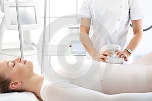 Flat stomach, a woman during a vacuum massage treatment using a professional device. Endermologie