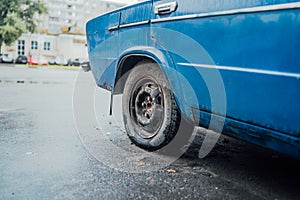Flat tire on a blue car. Clunkers