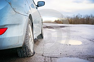 Flat tire of blue car on the road waiting for repair. Car tire leak because of nail pounding