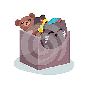 Flat vector icon of plastic box with cat face full of children toys. Brown teddy bear, yellow rubber duck and colorful