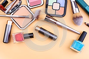 Flat view of cosmetics - lipstic, face-powder, brushes, nail polish.