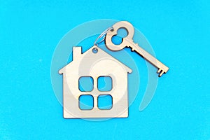 Flat Wooden Key and House-Shaped Keychain on Blue