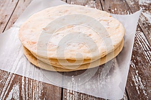 Flatbread, pita or pizza crust on wooden kitchen table