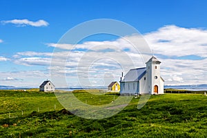 Flateyjarkirkja church and couple of living houses with meadow i