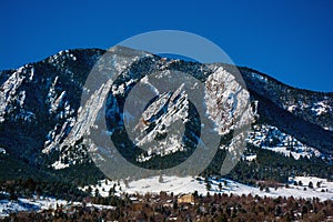 The Flatirons Mountains in Boulder, Colorado on a Snowy Winter Day photo