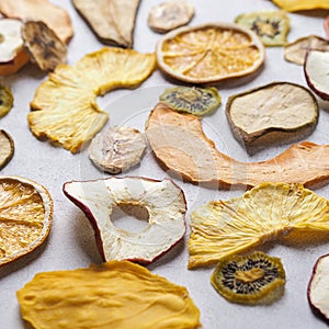 Flatlay of assorted Colorful Dried Fruits. Persimmon, pear. apple, melon, pineapple, kiwi and orange on white background