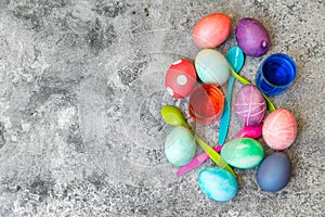 Flatlay, colorful dyed easter eggs, spoons and egg dyes on grey photo