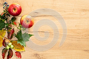 Flatlay composition with autumn fallen leaves and apple on wooden background. Autumn frame. Flat lay, top view, copy space