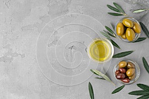 Flatlay composition of olives and olive oil on gray background