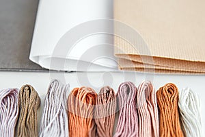 Flatlay creativity: canva aida beige, gray and white and multi-colored floss thread