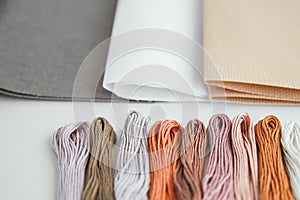 Flatlay creativity: canva aida beige, gray and white and multi-colored floss thread