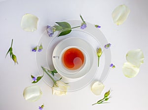 Flatlay with elegant tea set surrounded by flowers