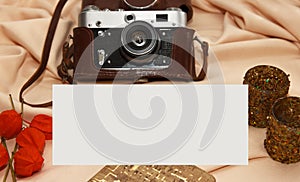 Flatlay. Film camera in case, notebook, fisalis and candlesticks lie on a beige background
