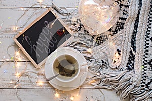 Flatlay with green tea, blackboard with handwritten text hygge, blanket and lantern