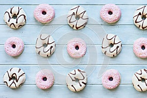 Flatlay of Many Pink and White Donuts on Light Blue Table