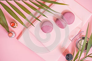 Flatlay of notebook, cake macaron, flower on pink table. Beautiful breakfast with macaroon