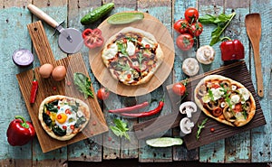 Flatlay of pizza party. Homemade pizzas and raw vegetables in ab