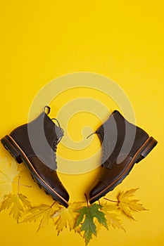 Flatlay Of Premium Dark Brown Grain Brogue Derby Boots Made of Calf Leather with Rubber Sole Placed With Yellow Maple Leaves Over