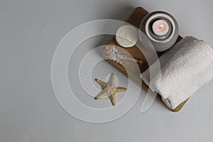 Flatlay spa massage treatments top view layout. Starfish white twisted rolled towels bath salt scrub oil candles. Self-care