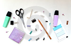 Flatlay stationery composition, writing objects in random order scissors, marker, notepad, paperclip, eraser, pencil, stickers,