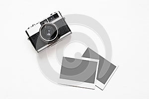 Flatlay vintage retro camera on wooden white background with empty instant paper photo placed your pictures. Top view