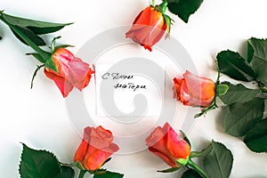 flatlay on a white background orange roses and handwritten gift card with the inscription happy mother s day